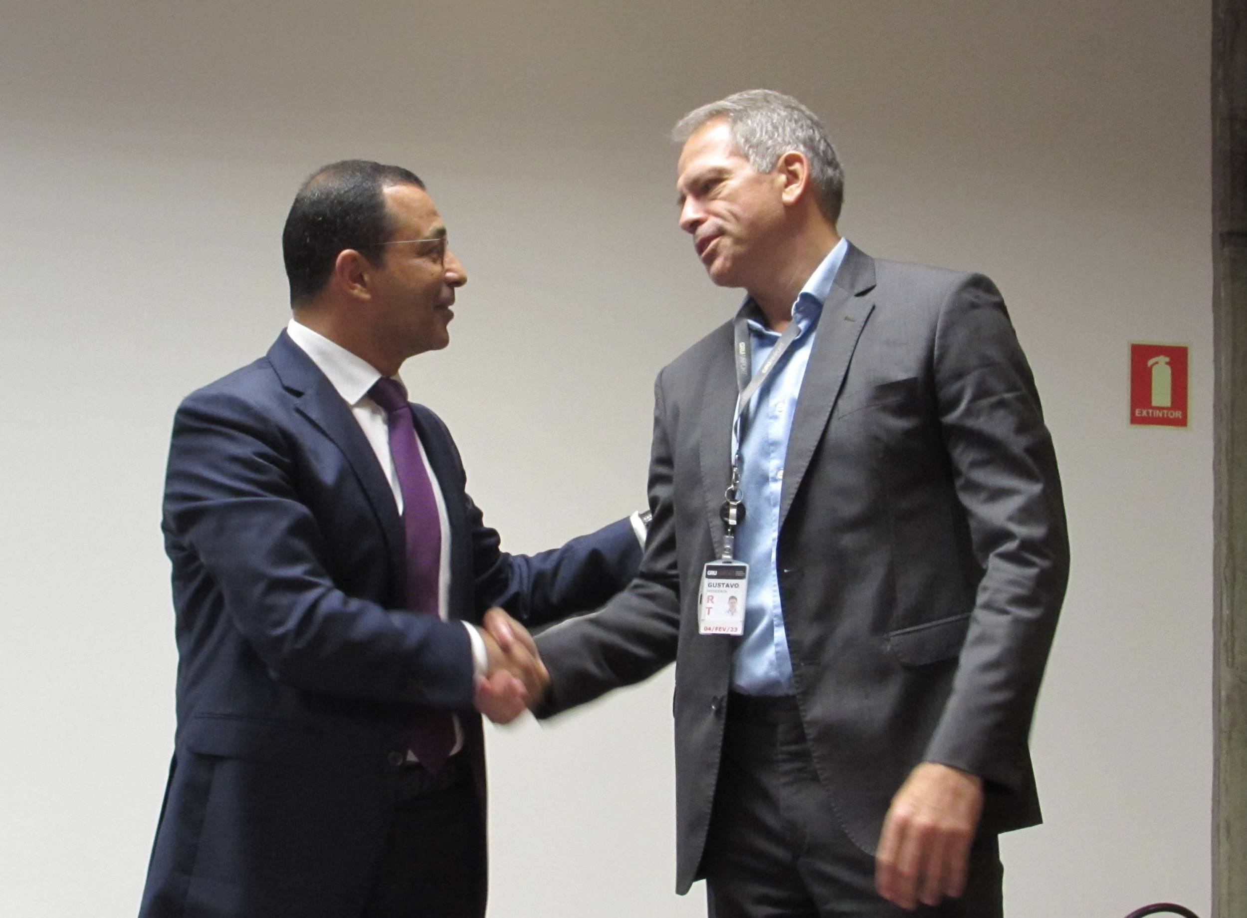 Fethi Chebil (L) of AEPM and Gustavo Figueiredo, CEO of GRU Airport, shake hands after signing the lease for the VIP Terminal.