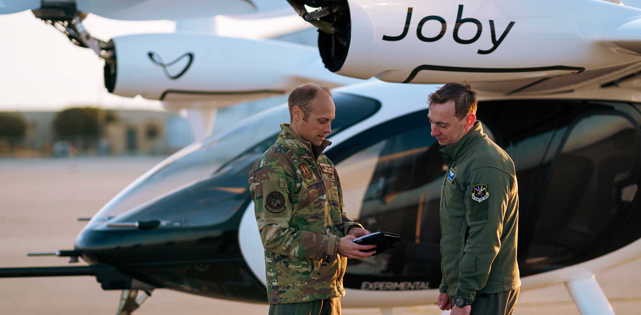 Two U.S. Air Force test pilots are pictured standing in front of Joby's eVTOL aircraft.