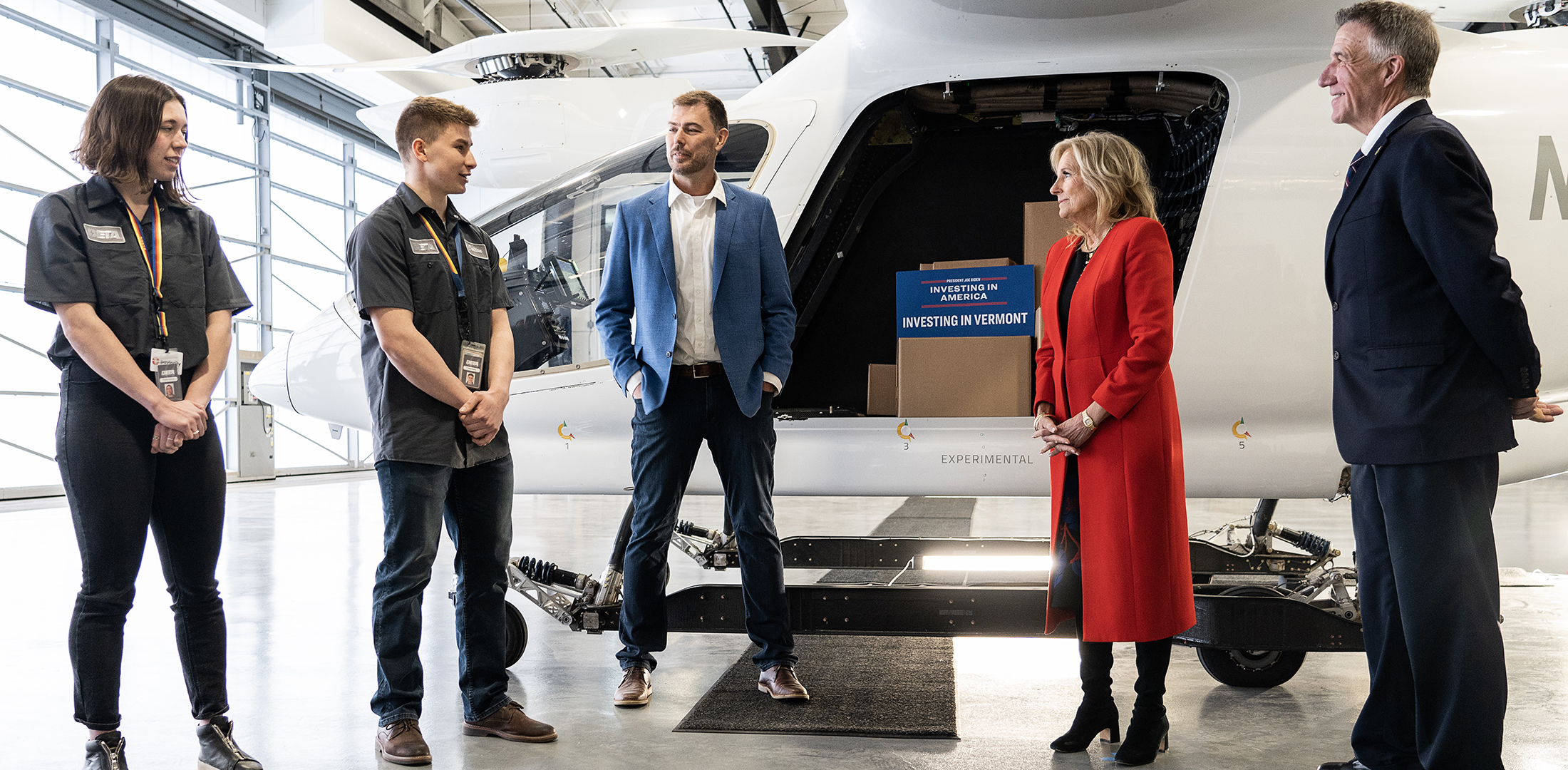 (From left) Beta Technologies interns Phoebe Peckham and Colton Poulin, and company founder/CEO Kyle Clark speak with first lady Jill Biden and Vermont Gov. Phil Scott at Beta's headquarters in South Burlington, Vermont, on April 5, 2023.