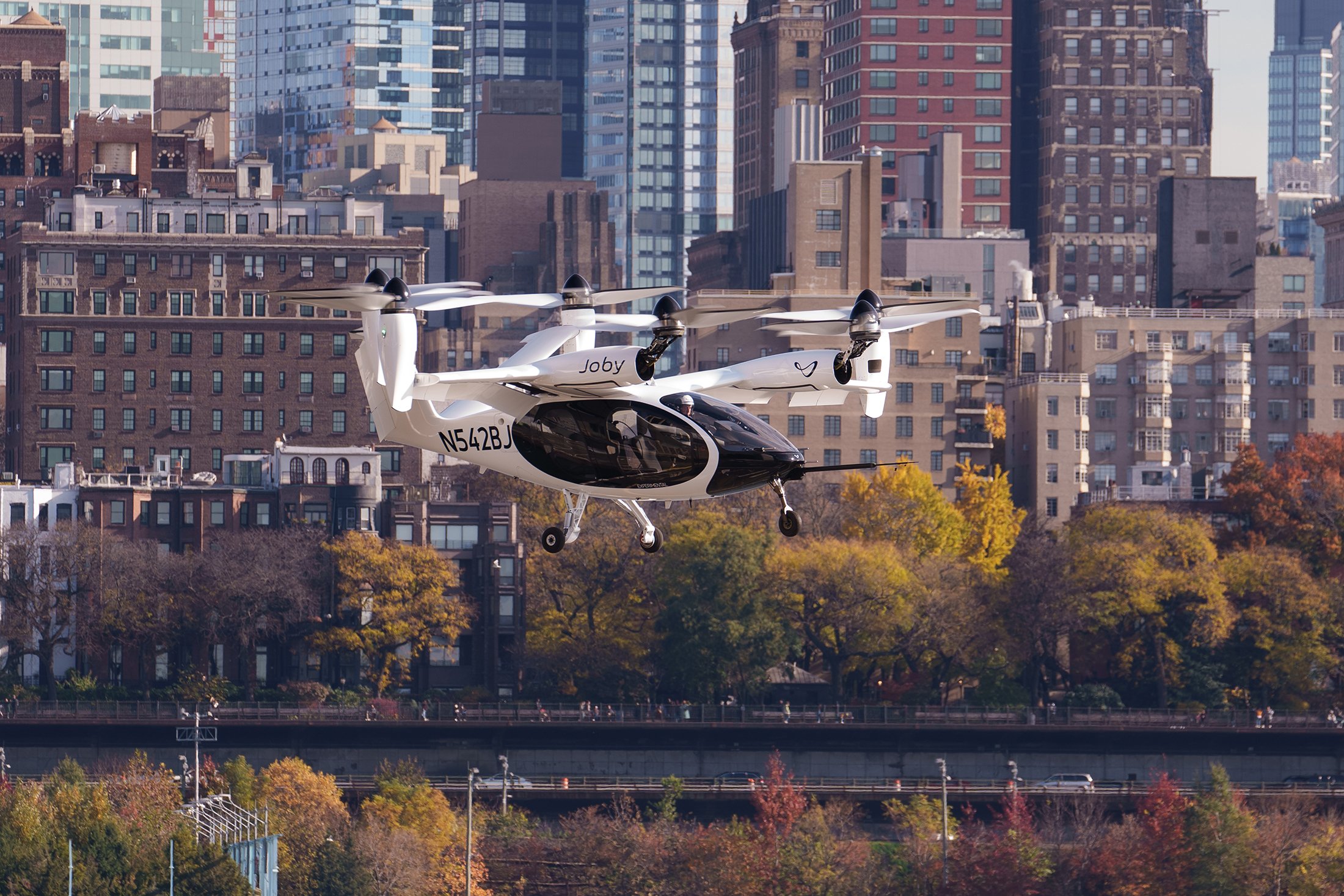 Joby's eVTOL aircraft is pictured flying in front of the NYC skyline