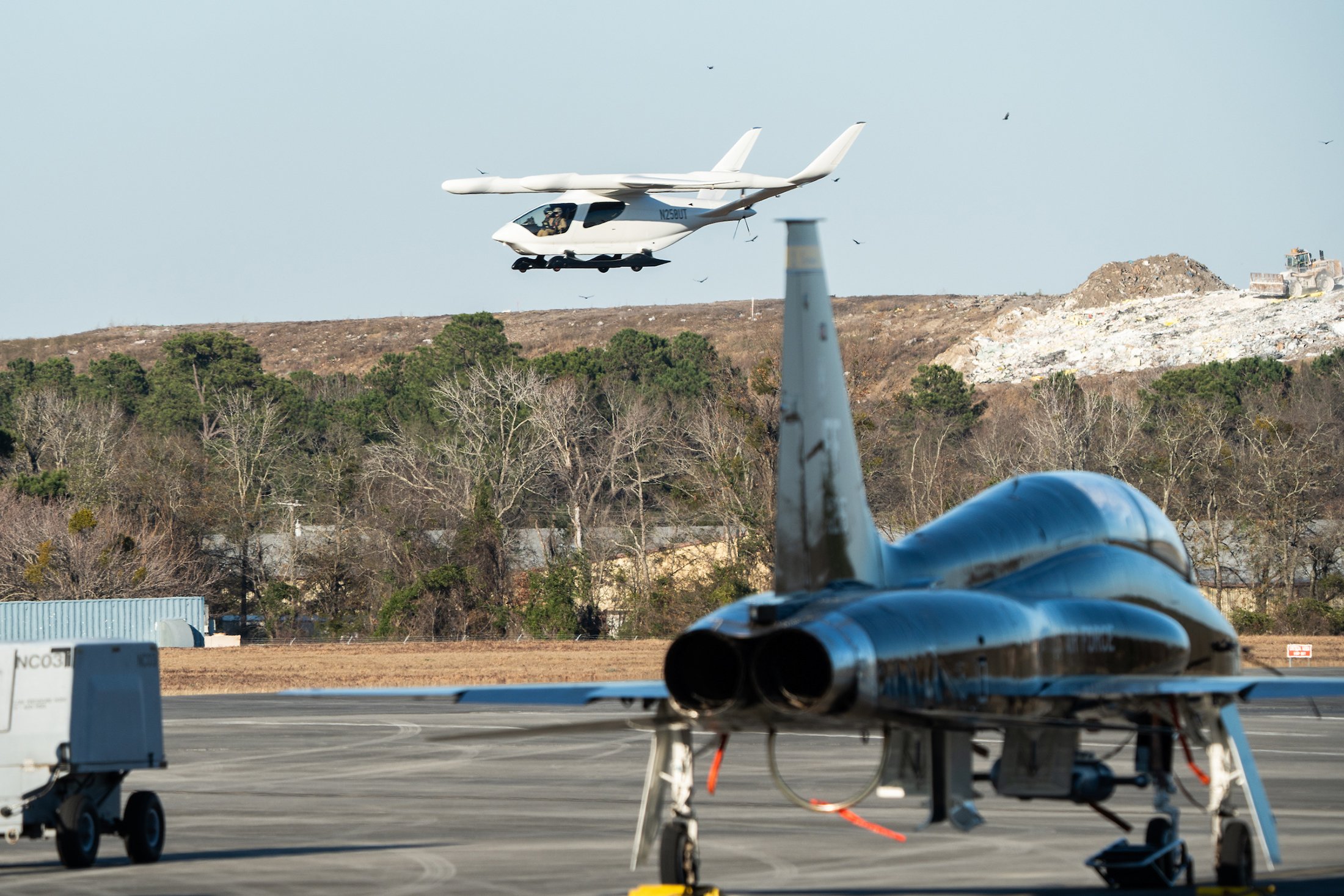 Beta's Alia prototype is pictured in flight with a fighter jet in the foreground