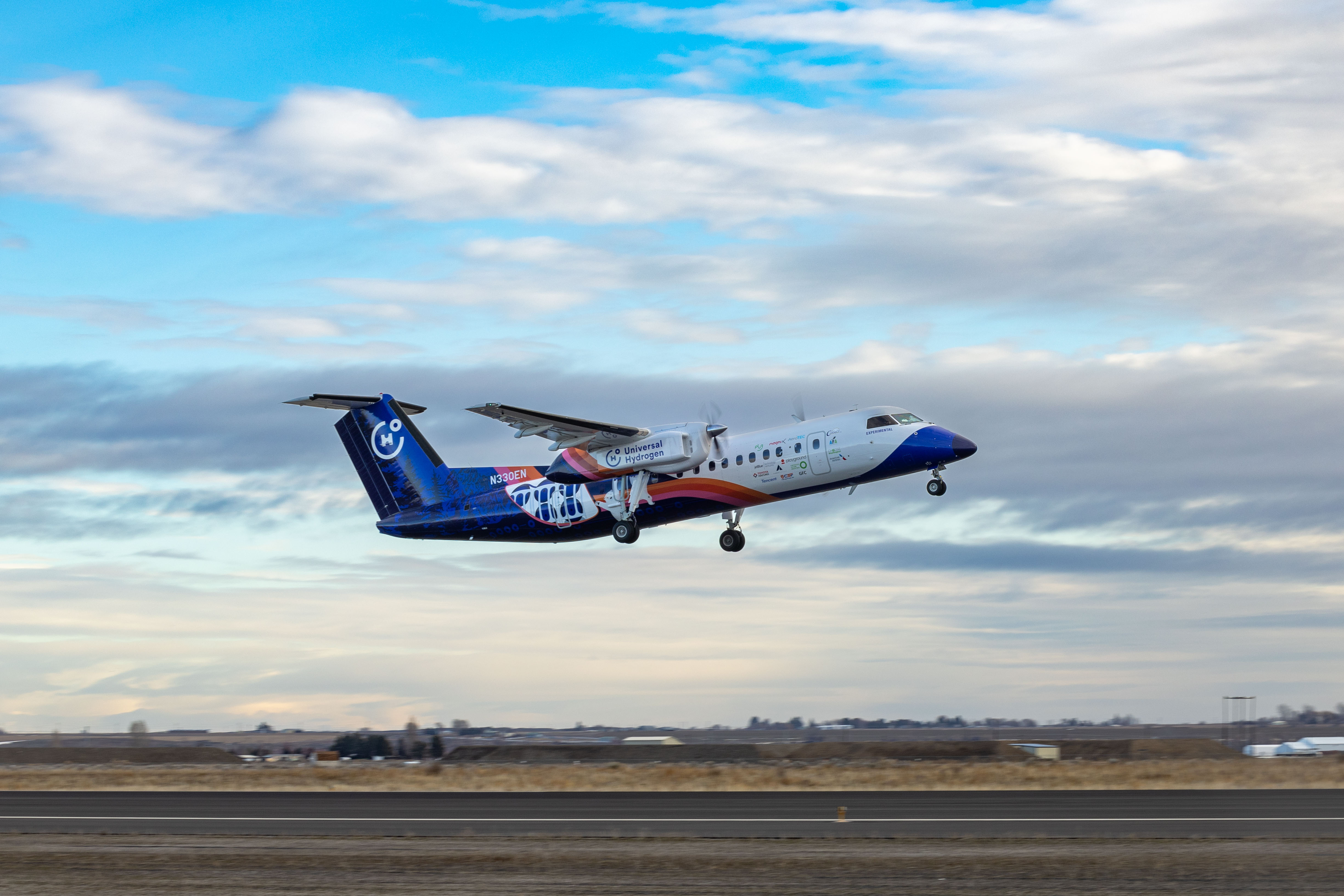 Universal Hydrogen's "Lightning McClean," a Dash 8 twin turboprop retrofitted with a hydrogen fuel cell propulsion system in one of its nacelles, is pictured in flight.