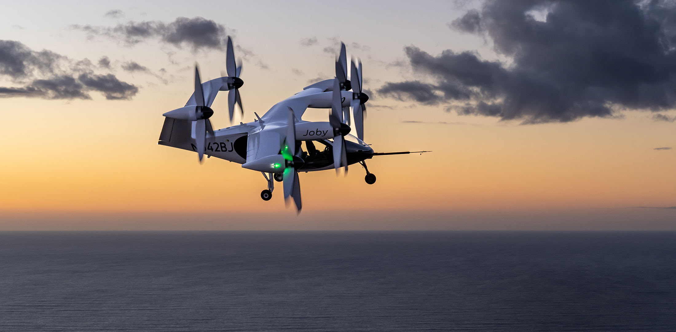 Joby's eVTOL aircraft flies over the Pacific Ocean during a flight test at the company's facility in Marina, California.