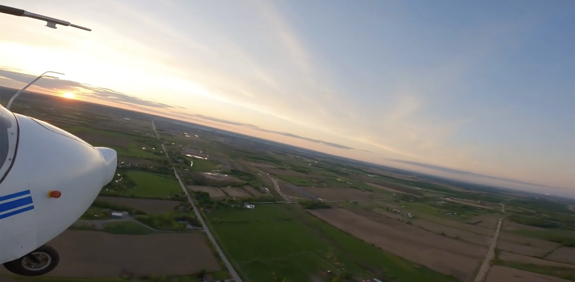 A view from the wing of Ribbit's airplane shows farmland in rural northern Canada.