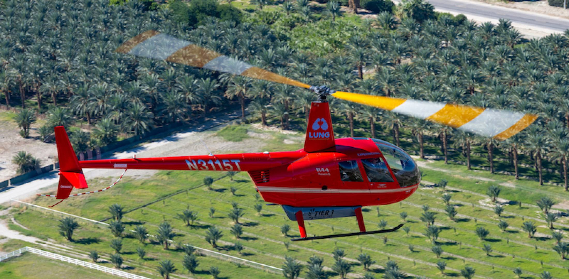 An R44 helicopter powered entirely by an electric propulsion system flies over Coachella on the way to Palm Springs International Airport.