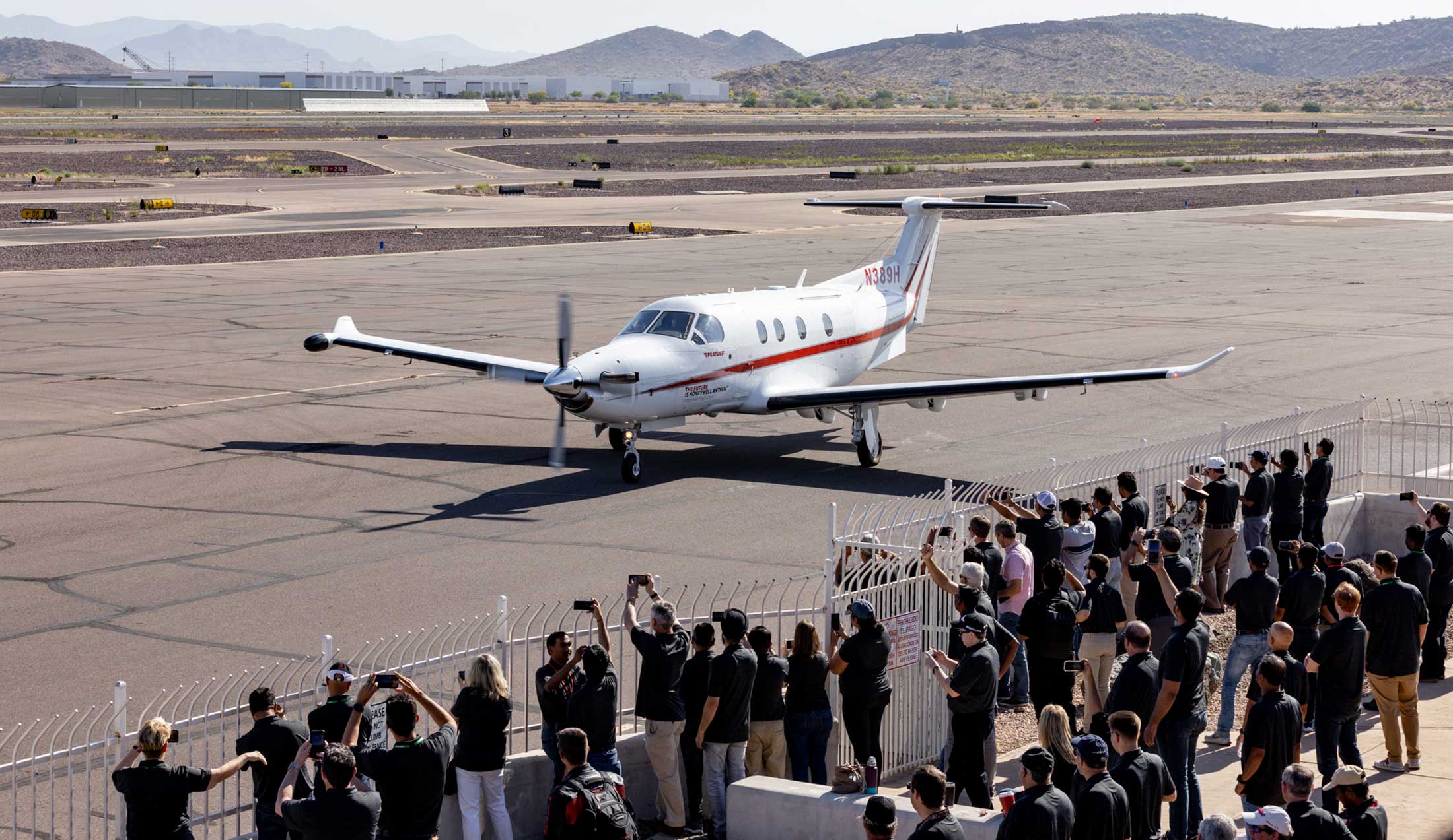 Honeywell's PC-12 test aircraft is pictured on the runway with crowd gathered to watch the milestone flight