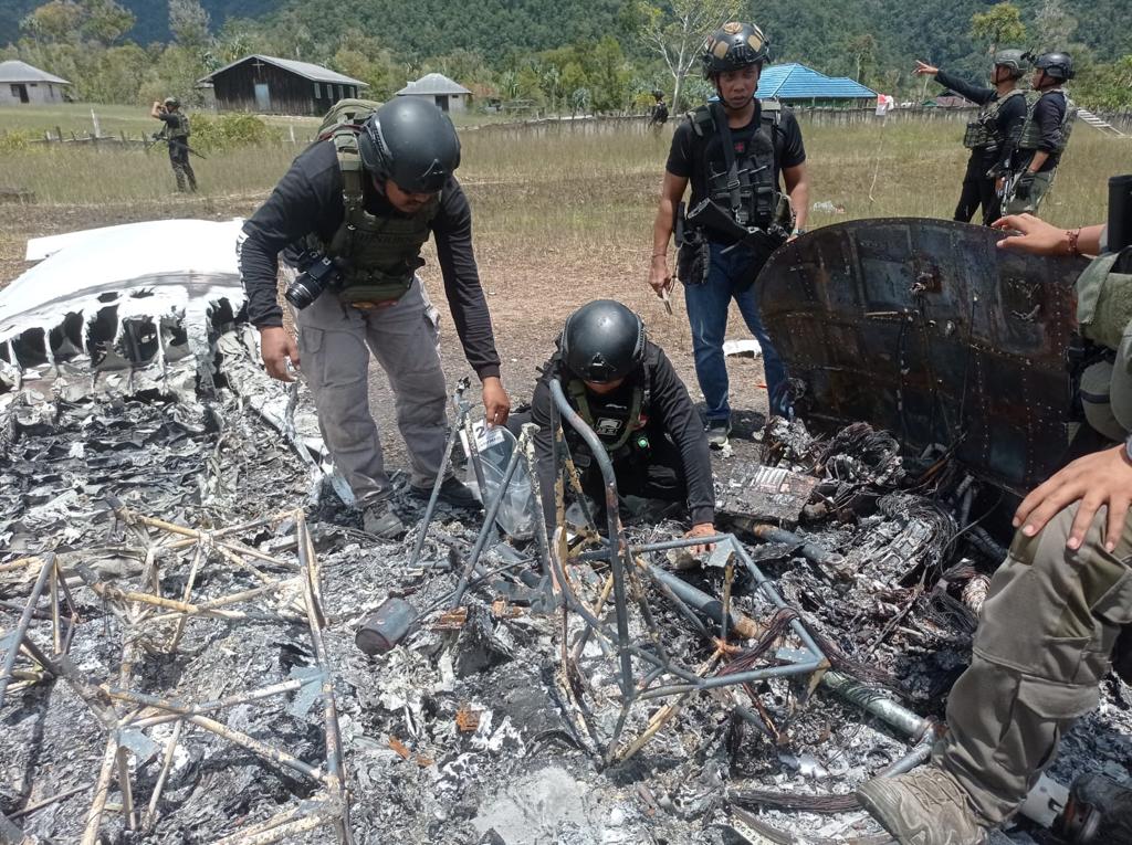 Indonesia police examine the burnt out remains of a Susi Air Pilatus PC-6 aircraft.