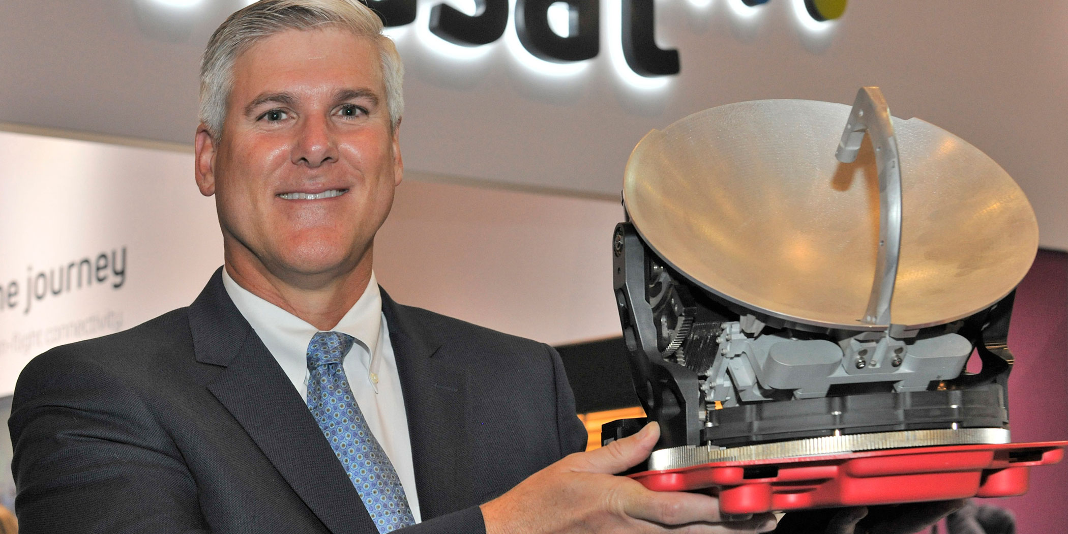 James Person holds Viasat’s Ka-band antenna which brings high-speed broadband to mid- and super-midsize jets.